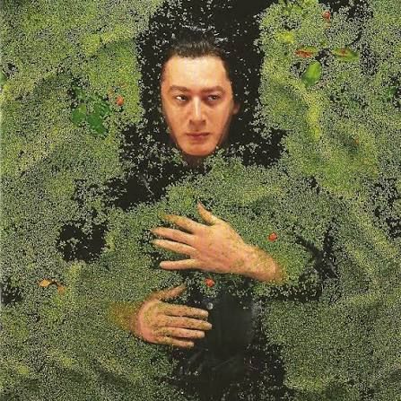 On voit Alain Bashung allongé à la surface d’une eau sombre et verdâtre. Son visage et une partie de son corps sont visibles, tandis que des lentilles d’eau recouvrent la surface autour de lui. L’image est sombre, calme et mystérieuse.