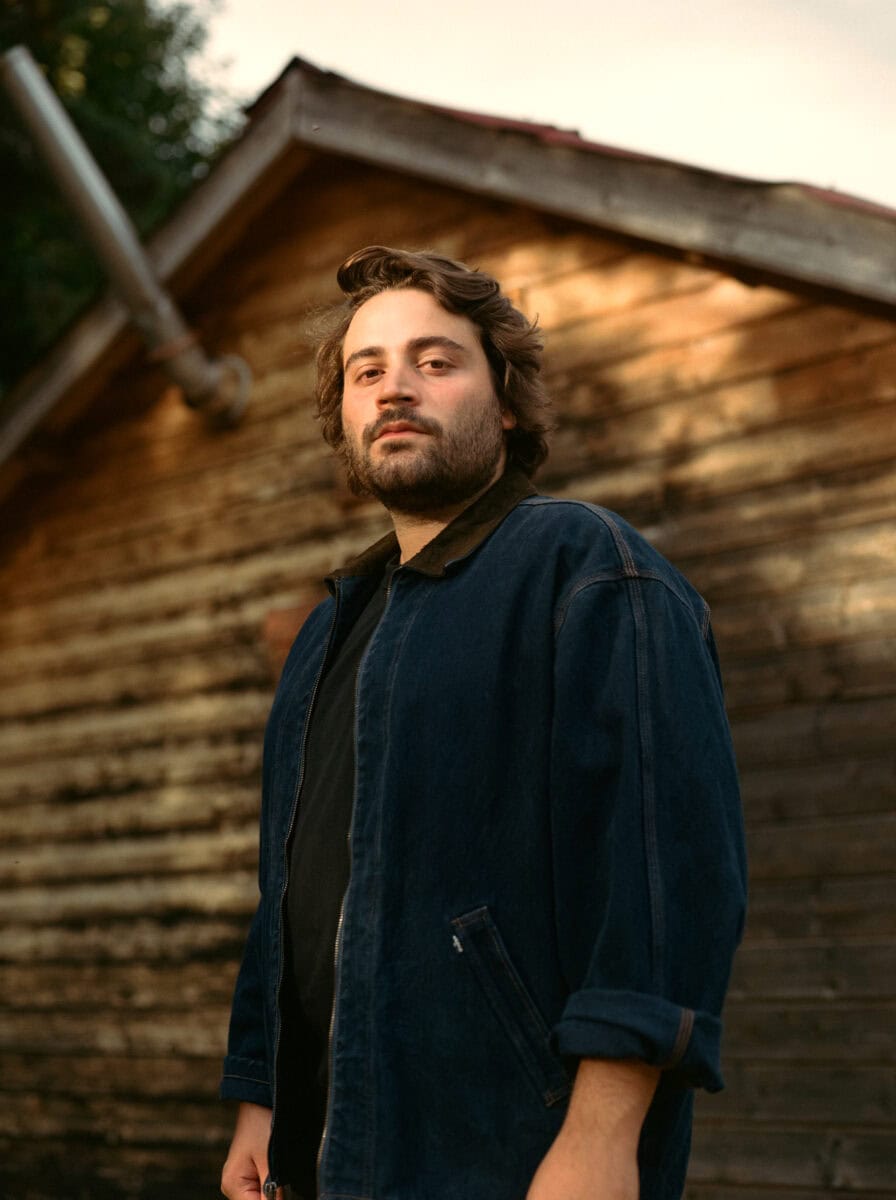 Le chanteur et musicien belge Noé Preszow pose devant un chalet