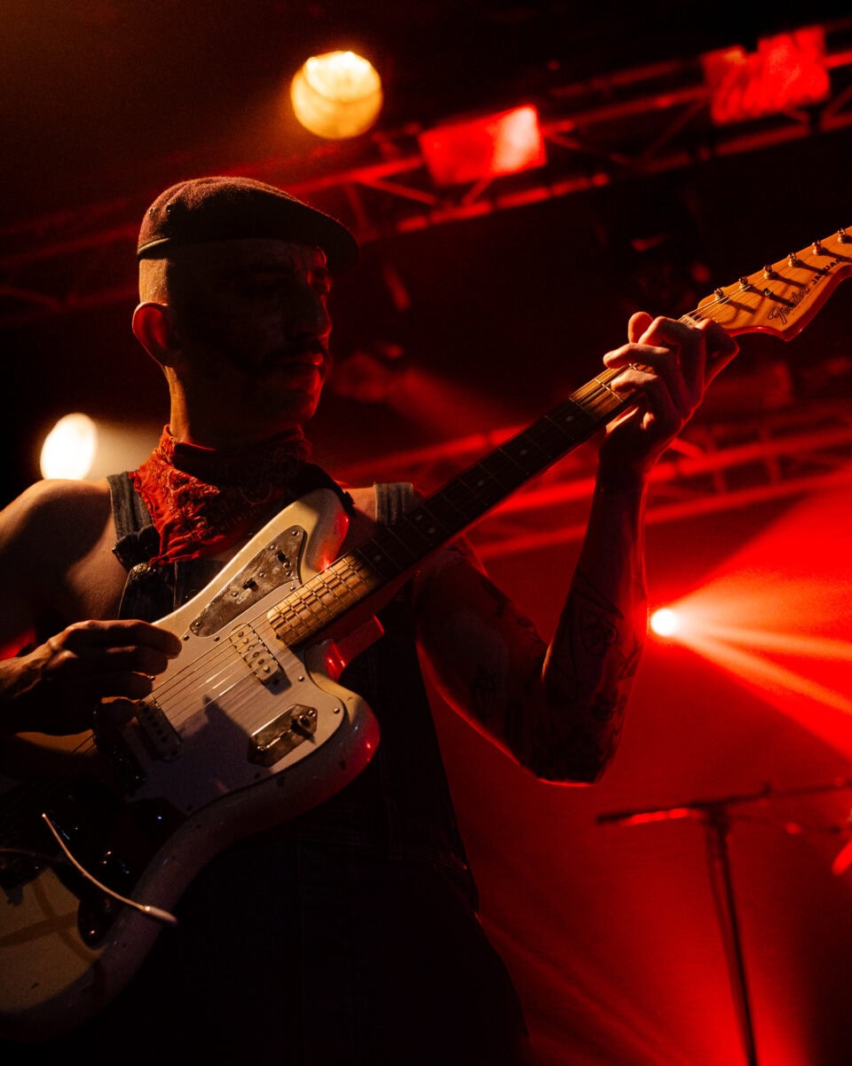 Un guitariste sous les lumières rouges de la seine